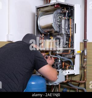 Maestro di gas service, regola la combustione di gas in caldaia gas Foto Stock