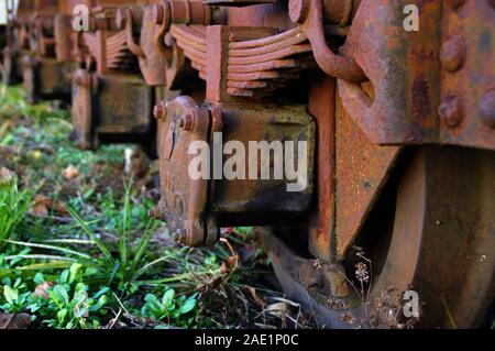 Rusty treno di ruote con molle. Industria dimenticata. La formazione di ruggine sul vecchio meccanismo. Foto Stock
