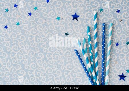 Eco-friendly cannucce di carta con vari pattern in colore blu per il Natale o la festa di Capodanno. Sfondo lucido con accessori di festa per bevande. Ch Foto Stock