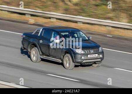 Movimento sfocate auto Mitsubishi L200 Barbaro Di-D che viaggiano a velocità sulla M61 Autostrada lenta velocità dello shutter di movimento del veicolo Foto Stock