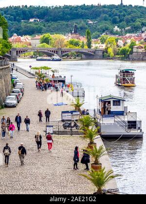Turisti che camminano lungo il fiume Moldava vicino al ponte Svatopluk Čech Città Vecchia Praga Repubblica Ceca. Foto Stock