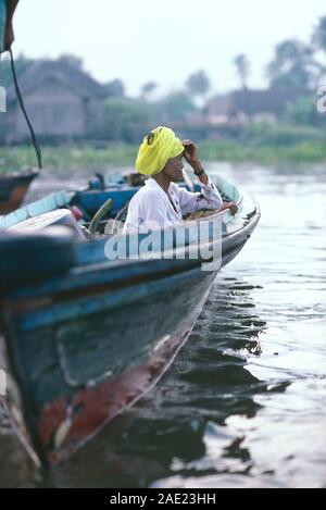 Indonesia. Borneo. A sud di Kalimantan. Fiume Barito. Vista laterale della vecchia donna seduta in barca open. Foto Stock