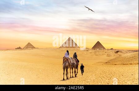 I beduini sui cammelli andando alle Piramidi di Giza in Egitto Foto Stock
