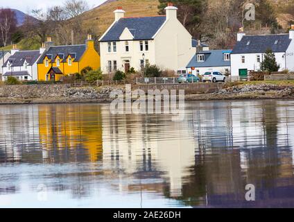 Guardando attraverso il villaggio di Dornie riflessa in Loch Long, Western Ross, Highlands Occidentali, Scotland, Regno Unito in Marzo Foto Stock