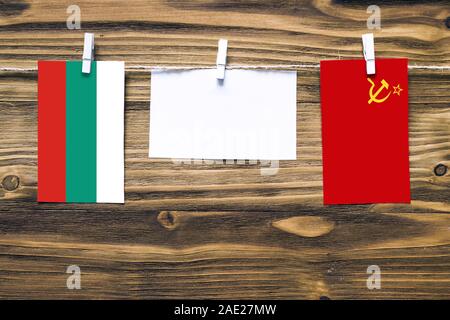 Appendere le bandiere di Bulgaria e Unione Sovietica attaccata alla corda con vestiti perni con copia spazio bianco sulla nota carta su sfondo di legno.Diplomatic rela Foto Stock