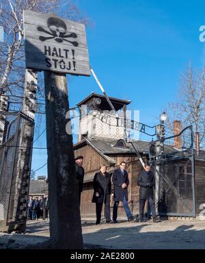 06 dicembre 2019, Polonia, Oswiecim: Cancelliere federale Angela Merkel (CDU) visite il tedesco ex campo di concentramento di Auschwitz e passeggiate sotto il cancello di ingresso con le parole "Arbeit macht frei" (Lavoro rende libero) insieme con il Primo Ministro polacco Mateusz Morawiecki (a destra di Merkel) e Piotr Cywinski (a sinistra di Merkel), Direttore del Memoriale di Auschwitz-Birkenau e Presidente della Fondazione di Auschwitz-Birkenau. Andrzej Kacorzyk, Vice Direttore del Museo di Auschwitz-Birkenau, va all'estrema destra. Merkel ha accettato un invito da parte della fondazione di Auschwitz-Birkenau, whi Foto Stock