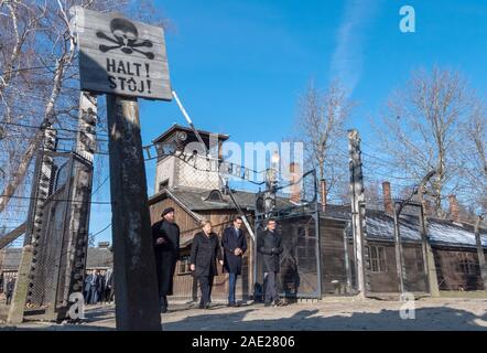 06 dicembre 2019, Polonia, Oswiecim: Cancelliere federale Angela Merkel (CDU) visite il tedesco ex campo di concentramento di Auschwitz e passeggiate sotto il cancello di ingresso con le parole "Arbeit macht frei" (Lavoro rende libero) insieme con il Primo Ministro polacco Mateusz Morawiecki (a destra di Merkel) e Piotr Cywinski (a sinistra di Merkel), Direttore del Memoriale di Auschwitz-Birkenau e Presidente della Fondazione di Auschwitz-Birkenau. Andrzej Kacorzyk, Vice Direttore del Museo di Auschwitz-Birkenau, va all'estrema destra. Merkel ha accettato un invito da parte della fondazione di Auschwitz-Birkenau, whi Foto Stock