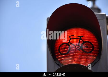 Bicicletta rosso semaforo su un cielo blu sullo sfondo Foto Stock