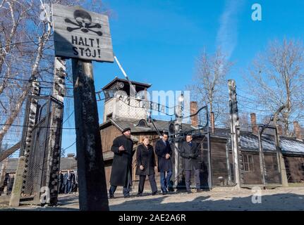 Dpatop - 06 dicembre 2019, Polonia, Oswiecim: Cancelliere federale Angela Merkel (CDU) visite il tedesco ex campo di concentramento di Auschwitz e passeggiate sotto il cancello di ingresso con le parole "Arbeit macht frei" (Lavoro rende libero) insieme con il Primo Ministro polacco Mateusz Morawiecki (a destra di Merkel) e Piotr Cywinski (a sinistra di Merkel), Direttore del Memoriale di Auschwitz-Birkenau e Presidente della Fondazione di Auschwitz-Birkenau. Andrzej Kacorzyk, Vice Direttore del Museo di Auschwitz-Birkenau, va all'estrema destra. Merkel ha accettato un invito da parte di fondazioni di Auschwitz-Birkenau Foto Stock