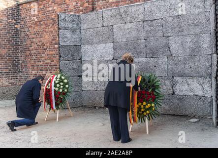 06 dicembre 2019, Polonia, Oswiecim: Cancelliere Angela Merkel (CDU) e Mateusz Morawiecki, Primo ministro della Polonia, in corrispondenza di una corona-posa cerimonia in occasione della morte parete della ex Germania campo di concentramento di Auschwitz. Merkel ha accettato un invito da parte della fondazione di Auschwitz-Birkenau, che celebra il suo decimo anniversario con una cerimonia. Foto: Robert Michael/dpa-Zentralbild/dpa Foto Stock