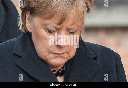 Oswiecim, Polonia. 06 Dic, 2019. Il cancelliere Angela Merkel (CDU) piegato dopo la posa di una corona al muro della morte nella ex Germania campo di concentramento di Auschwitz. Ella ha accettato un invito da parte della fondazione di Auschwitz-Birkenau, che celebra il suo decimo anniversario con una cerimonia. Credito: Robert Michael/dpa-Zentralbild/dpa/Alamy Live News Foto Stock