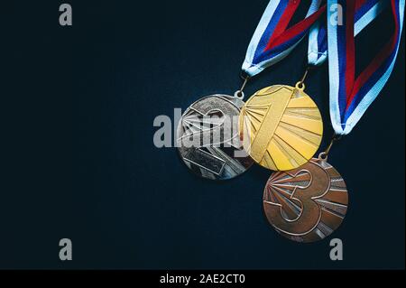 Oro, d'Argento e Medaglia di Bronzo, sport foto trofeo, sfondo nero Foto Stock