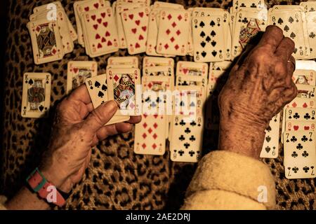 Vecchia donna giocando le carte di pazienza. Foto Stock