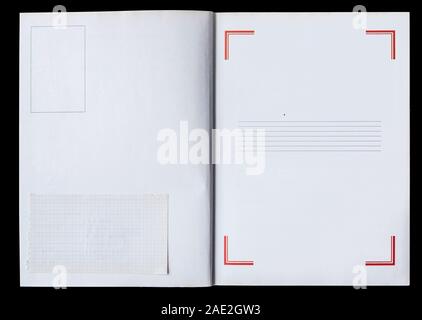 Il Libro bianco è dispiegata che mostra le pagine bianche con un telaio e un pezzo di carta usata isolata su uno sfondo nero. Foto Stock