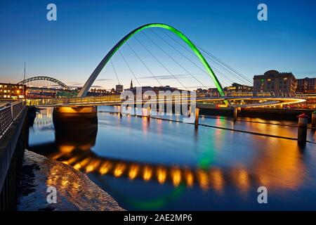 Il Gateshead Millennium Bridge illuminato al crepuscolo e che attraversano il fiume Tyne Foto Stock