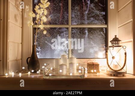 Bella candele accese e luci fairy sul davanzale interno Foto Stock