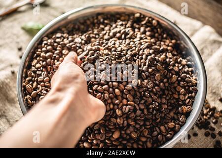 Mano azienda appena tostato Arabica aromatici chicchi di caffè. Sfondo di caffè con spazio per il testo Foto Stock
