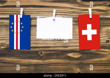 Appendere bandiere di Capo Verde e la Svizzera attaccata alla corda con vestiti perni con copia spazio bianco sulla nota carta su sfondo di legno.Diplomatic rel Foto Stock