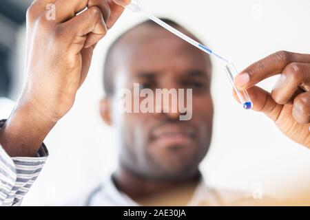 Incentrato sulla fotografia di mano maschio che tenendo la pipetta Foto Stock