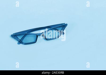 Occhiali da sole elegante isolato sull'azzurro del colore di sfondo. Foto Stock