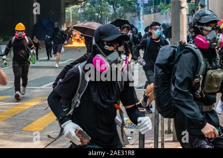 HongKong - Novembre 18, 2019: manifestanti in esecuzione, in fuga dalla polizia gas lacrimogeni sul modo di essere assediata Politecnico durante il 2019 HongKong proteste Foto Stock