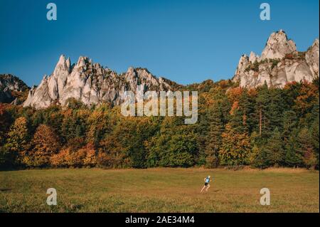 Uomo che corre sul prato di autunno vicino da maestose Foto Stock