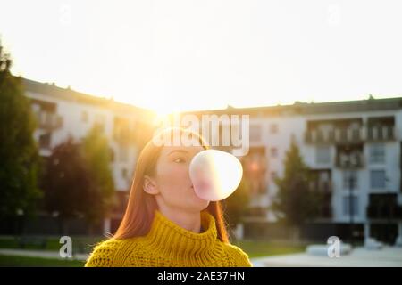 Giovane donna di chewing gum e rendere grande mongolfiera Foto Stock