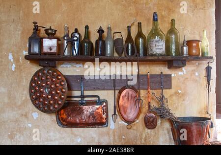 Cucina, bottiglie e implementa il legno vecchio ripiano, pentole in rame appeso, parete vernice scrostata, camera, Chateau Courmatin; castello del XVII secolo; la Borgogna; Taiz Foto Stock