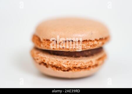 Deliziosi dolci macaron disposti in righe e colorati di amaretto dessert su sfondo bianco. -L'immagine Foto Stock