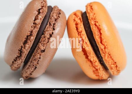 Deliziosi dolci macaron disposti in righe e colorati di amaretto dessert su sfondo bianco. -L'immagine Foto Stock