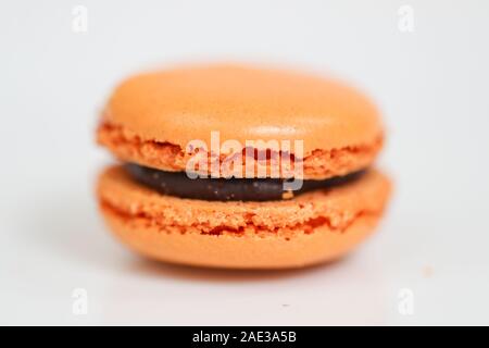 Deliziosi dolci macaron disposti in righe e colorati di amaretto dessert su sfondo bianco. -L'immagine Foto Stock