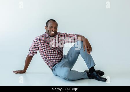 Felice afro american uomo seduto sul pavimento Foto Stock