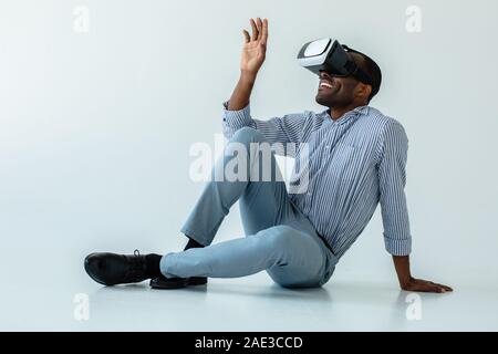 Positivo afro-americano che indossa gli occhiali VR Foto Stock