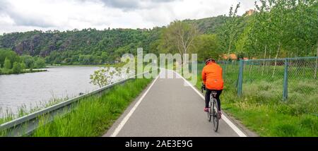 Donna traveler in sella ad una bicicletta sulla Moldava cycleway percorso ciclabile Eurovelo route 7 lungo il fiume Moldava tra Praga e Melnik Repubblica Ceca. Foto Stock