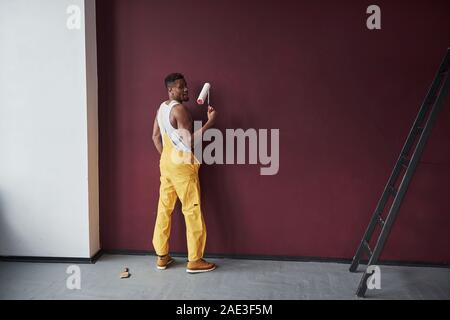 Iniziamo. Giovane africana lavoratore americano in giallo sono uniformi in alcuni job Foto Stock