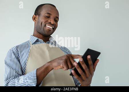 Basso angolo di allegro afro maericna cameriere Foto Stock