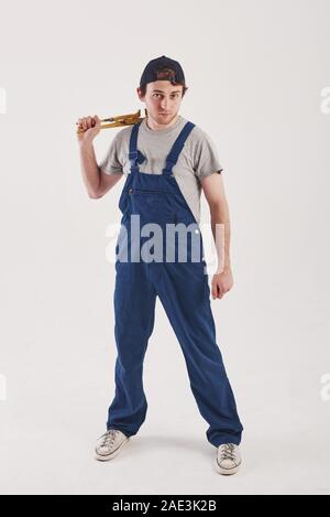 Chiamami se hai bisogno di aiuto. Uomo in uniforme blu si erge contro uno sfondo bianco in studio Foto Stock