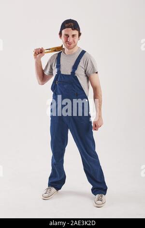 Vista frontale. Uomo in uniforme blu si erge contro uno sfondo bianco in studio Foto Stock