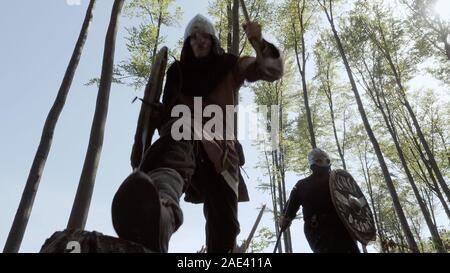 I vichinghi in esecuzione nella foresta a combattere in una battaglia Foto Stock