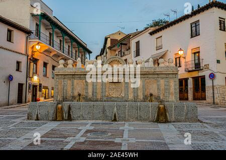 Vecchia fontana con protezioni emblematico della città di Chinchon nella piazza principale. Madrid la comunità. Spagna. Foto Stock