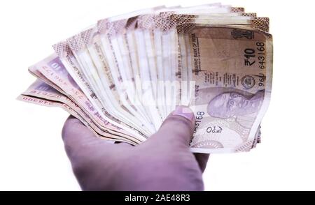 Mano con dieci Indiani rupee note, sfondi bianchi Foto Stock