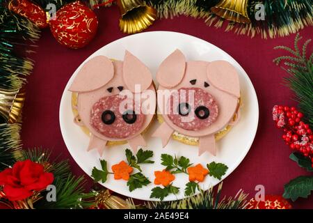 Panini divertenti per bambini a forma di maiale carino con formaggio e salsicce, arte cibo idea, vista dall'alto Foto Stock