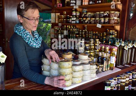 Donna anziana che lavorano in strada della famiglia dei prodotti agricoli in stallo la vendita di olio di oliva, formaggio e produrre, Panorama di stallo Limski Fjord, D75 road, Istria, Croati Foto Stock
