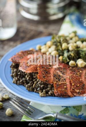 Affumicato caldo condito il salmone sul lenticchie con insalata di cavolo Foto Stock