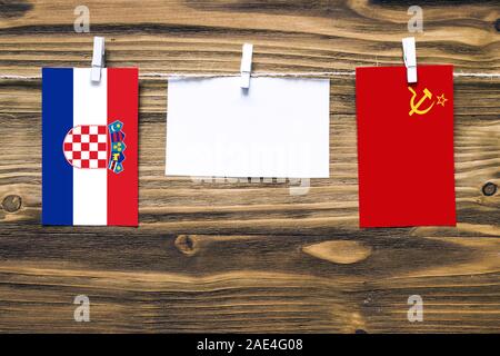 Appendere bandiere di Croazia e Unione Sovietica attaccata alla corda con vestiti perni con copia spazio bianco sulla nota carta su sfondo di legno.relat diplomatica Foto Stock