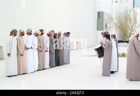 Uomini Emirati eseguendo il Yowla, una danza tradizionale nel patrimonio degli Emirati Arabi Uniti - Medio Orientale e cultura araba Foto Stock