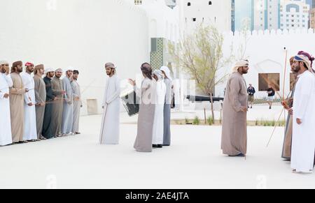 Uomini Emirati eseguendo il Yowla, una danza tradizionale nel patrimonio degli Emirati Arabi Uniti - Medio Orientale e cultura araba Foto Stock