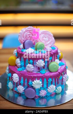 Colorate Amaretti fresca sulla bella torta per bambino compleanno di s. Candela in forma di numero 5 sulla superficie della torta. Blu con rosa a due piani di torta per vacanza. Felice Foto Stock