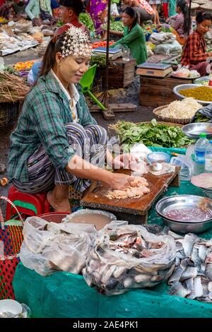 Una donna birmano indossando fiori freschi tra i capelli e la vendita di pesce fresco nel mercato ferroviario di Mandalay, Myanmar (Birmania) Foto Stock