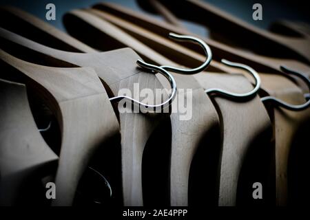 Una fila di coathangers in legno senza vestiti Foto Stock